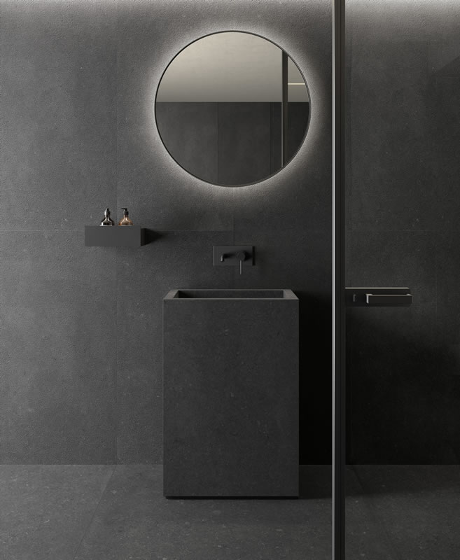 Dark stone basin with a wall mounted tap and full height tiles